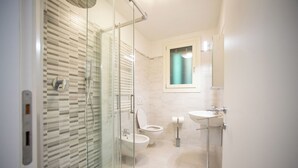 A modern bathroom with a glass shower enclosure, a toilet, and a sink. - Dimora Alba di Mare -apeliving- Pellestrina Ve (Venezia)