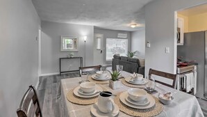 A dining area with a table set for four, including plates, bowls, and cutlery. - Cozy Home with a Huge Backyard! (Parma Heights)