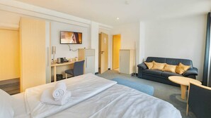 A hotel room with a bed, a desk, a sofa, and a TV. - AR Boutique Hotel Mannheim City (Mannheim)