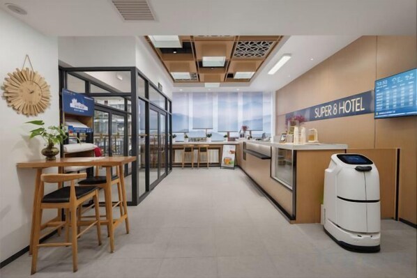 A hotel lobby with a reception desk, seating area, and a view of the sea. - Super 8 Hotel (Beijing Xizhimen) (Beijing)