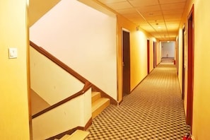 A hotel hallway with carpeted floors, wooden doors, and a staircase. - Super 8 Hotel (Beijing Zizhuyuan South Road) (Beijing)