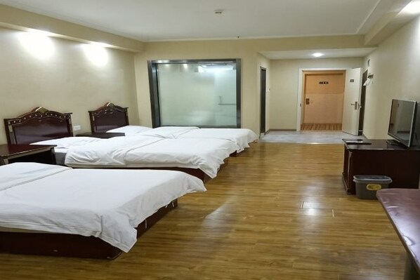 A hotel room with four beds, a television, a desk, and a trash bin. - Wutong Hotel (Beijing Changping University of Petroleum) (Beijing)