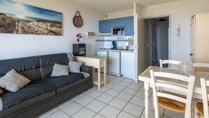 A compact living space with a sofa, dining table, and kitchenette. - Apartment for 6, ocean view, Mimizan Beach, parking (Mimizan-Mimizan Plage)