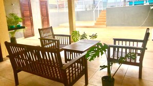 A covered patio with wooden furniture and potted plants. - Hotel Paraiso Natal EXPRESS (Natal)