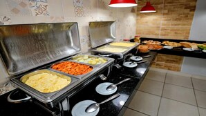 A buffet setup with various food items in metal containers, including scrambled eggs, carrots, and potatoes. - Hotel Paraiso Natal EXPRESS (Natal)