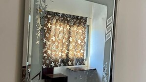 A bathroom with a decorative wall panel, a sink, and a mirror.