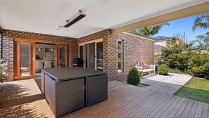 Un espacio al aire libre techado con una parrilla, una mesa y un banco.