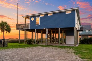 Une maison à deux étages avec un balcon, une véranda et un garage.