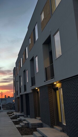 Un immeuble moderne à plusieurs étages, doté d’un toit plat, de grandes fenêtres et d’une façade en briques.