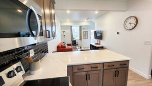 Eine moderne Küche mit einer großen Kochinsel, Edelstahlgeräten und Holzausbau.