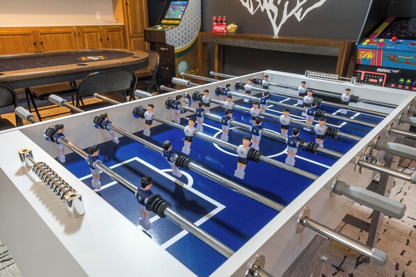 A foosball table with multiple players and a control panel.