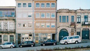 A row of buildings with a mix of architectural styles, including a beige building with multiple windows and a white van parked in front. - Campanha Apartment by Porto Stories (Porto)