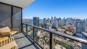 A balcony with a city view, a glass door, and a seating area with two chairs. - Sky High Stay Sleek Studio in Miami (Miami)