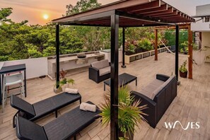 Relax on the rooftop terrace with a pergola, grill, and comfortable seating.