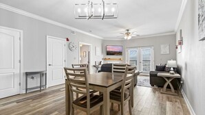 A dining area with a wooden table and chairs, a chandelier, and a ceiling fan. - Eagles Landing 1BR Heaven (Pigeon Forge)