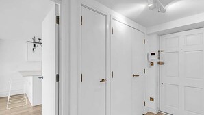 A room with white walls, a wooden floor, and a white door with a handle. - City Relay Radiant Chelsea Flat with City View (London)