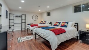 Un dormitorio con dos camas, un armario, un escritorio y una ventana.