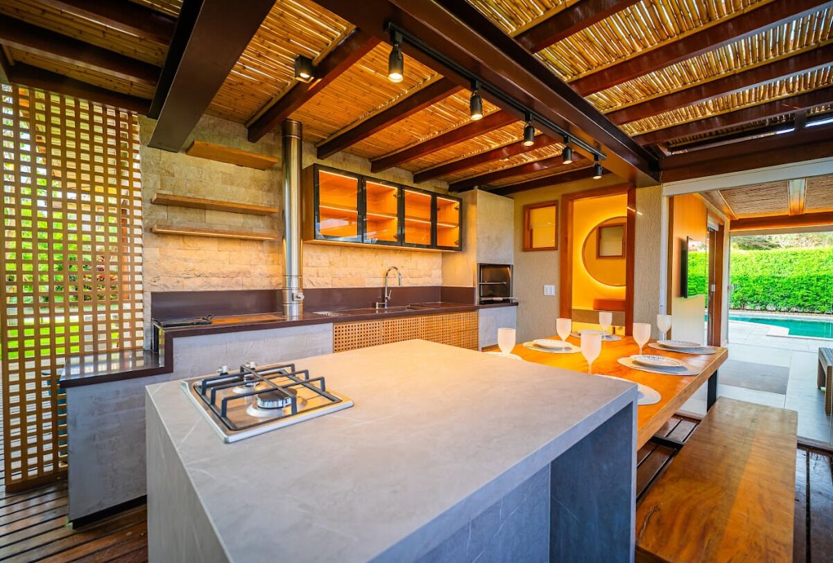 A modern kitchen with a central island, built-in appliances, and a view of a swimming pool.