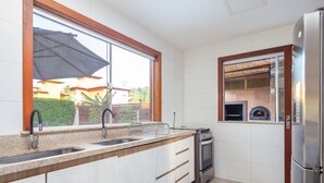 A kitchen with a window, stainless steel appliances, and a built-in oven.