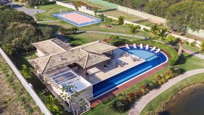 An aerial view of a resort with a swimming pool, a tennis court, and a covered patio area. - Bz01 Casa Piscina Priv 150m Da Praia  (Buzios)