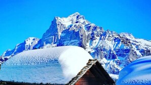 A wooden cabin with a snow-covered roof, surrounded by snow and mountains under a clear blue sky. - Concierge, Lake Thun/Alps Scenic Views by SwissHut (Sigriswil)