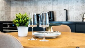 A dining table with two wine glasses and a small potted plant. - Luxury 2BD apartment in City Center (Tallinn)