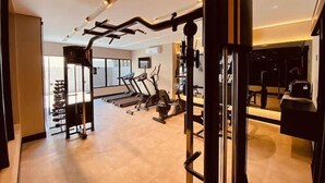 A modern gym with cardio machines, weightlifting equipment, and a large mirror. - Sky Concept 816 (Maceió)