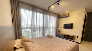 A modern hotel room with a large bed, a flat-screen TV, and a view of the city through sheer curtains. - Sky Concept 816 (Maceió)
