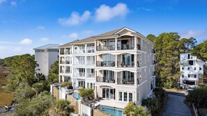 Un hôtel à plusieurs étages, doté de balcons, d’une piscine et offrant une vue sur le paysage environnant.