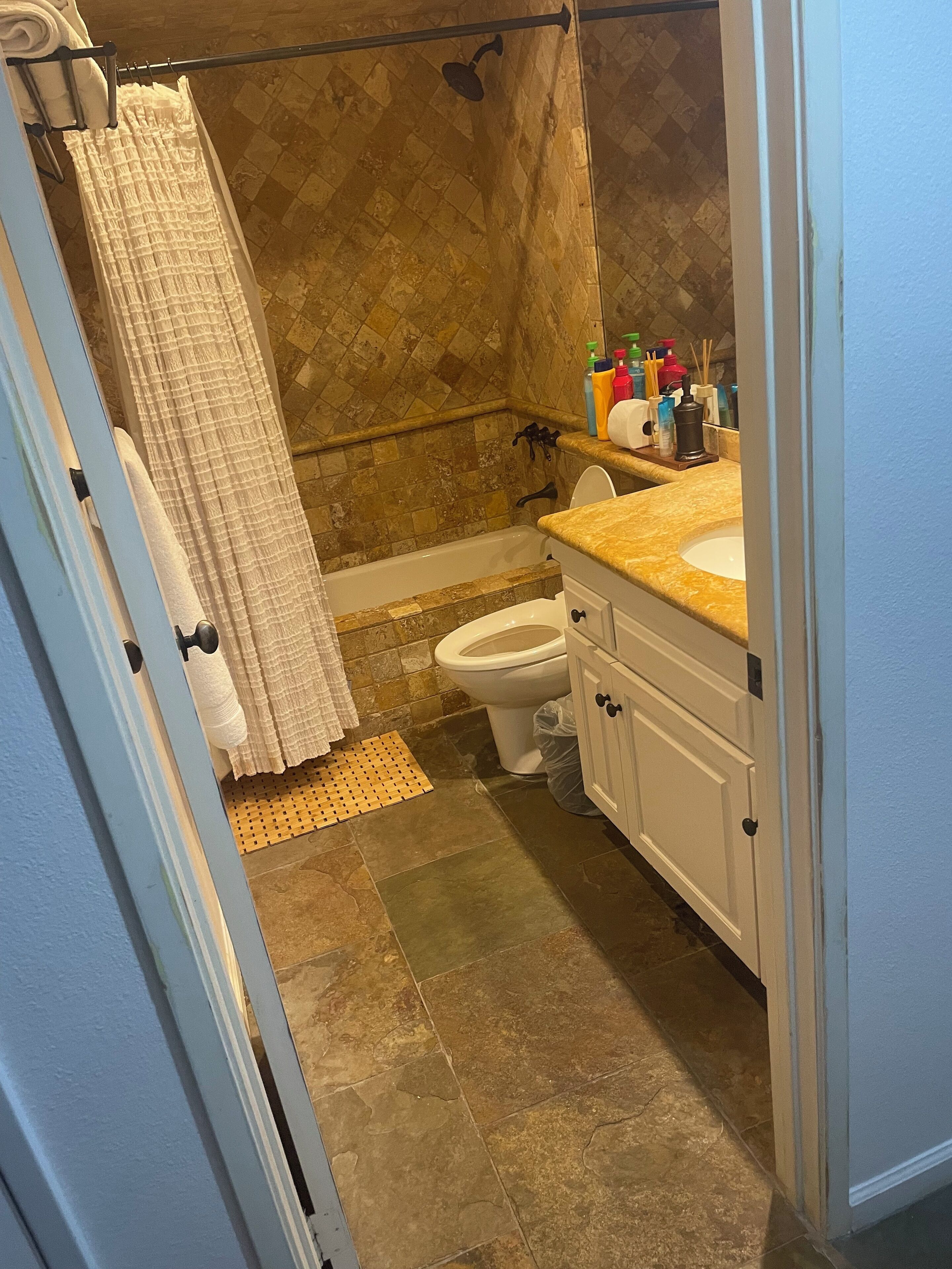 A bathroom with a shower, toilet, and sink.