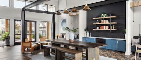 A modern kitchen with a central island, built-in shelves, and a large window overlooking the city.