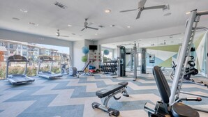 Un gimnasio con cintas de correr, balones de ejercicio y máquinas de pesas.
