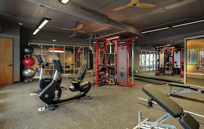 A gym with cardio equipment, weight machines, and free weights.