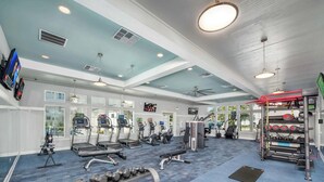 Une salle de sport spacieuse équipée de tapis de course, de vélos elliptiques et de matériel de musculation.