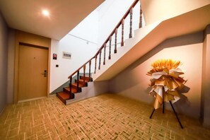 A staircase with wooden steps and a handrail, leading to an upper floor. - Shell Hotel (Jingjiang Taihe Wuyue Plaza Bus Station) (Jingjiang)
