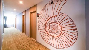 Un couloir orné d’une grande œuvre d’art en forme de spirale sur le mur.