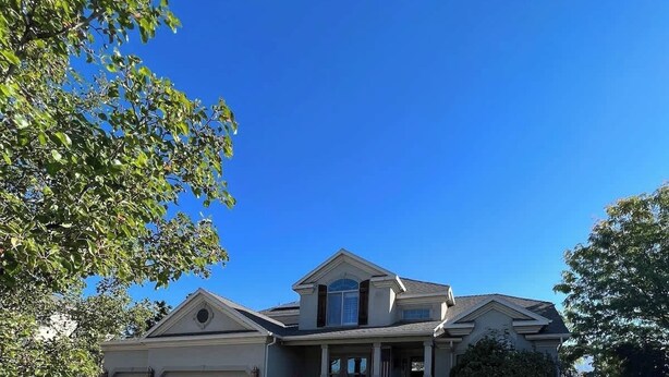 A two-story house with a front porch, a garage, and a well-maintained lawn. - Elegant Retreat & Small Gathering Home-Waffles too (Orem)