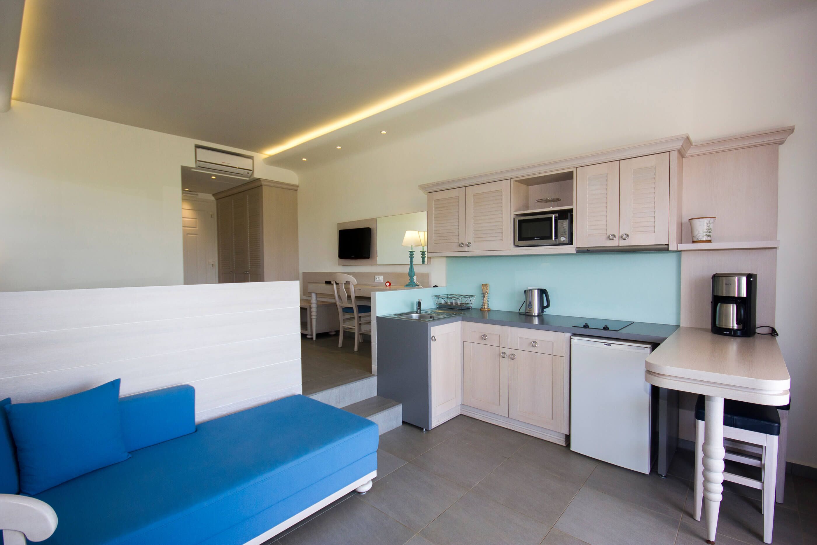 A compact kitchen with a microwave, sink, and a coffee maker on a counter.