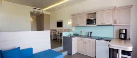 A compact kitchen with a microwave, sink, and a coffee maker on a counter.