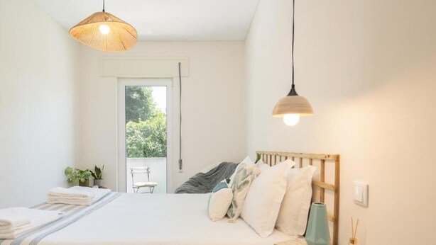 Une chambre à coucher avec un lit, une table de chevet et une fenêtre.