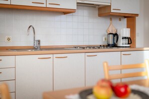 Una cocina moderna con un lavamanos de acero inoxidable, una cafetera y un hervidor sobre la encimera.