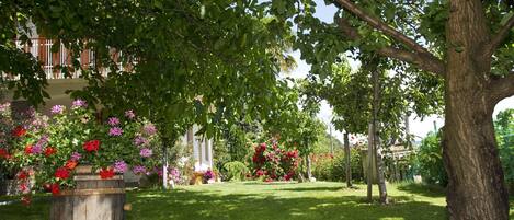 A well-maintained garden with a variety of flowering plants and a rustic wooden barrel.