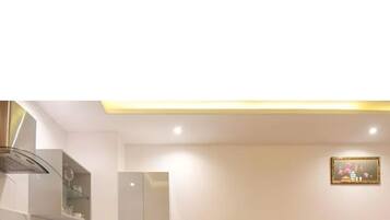 A compact room with a kitchenette, a dining area, and a bed.
