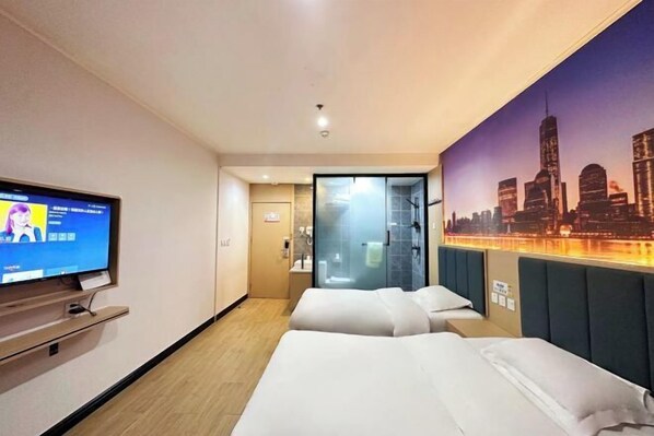 A hotel room with two beds, a television, and a cityscape mural on the wall.