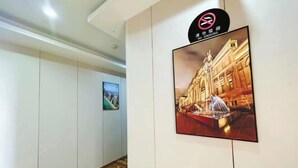 Egy folyosó, amelyen „dohányzás tilos” tábla található, egy keretezett kép egy szoborról, amelynek része egy szökőkút, és egy mintás padló.