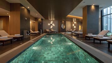 Una piscina techada, sillones reclinables de piscina
