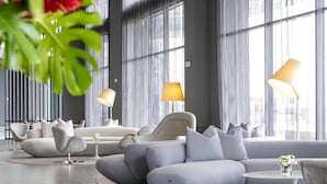 A modern living room with a sectional sofa, two side tables, and a lamp. - Wyndham Grand Costa Del Sol Lima Airport (Callao)