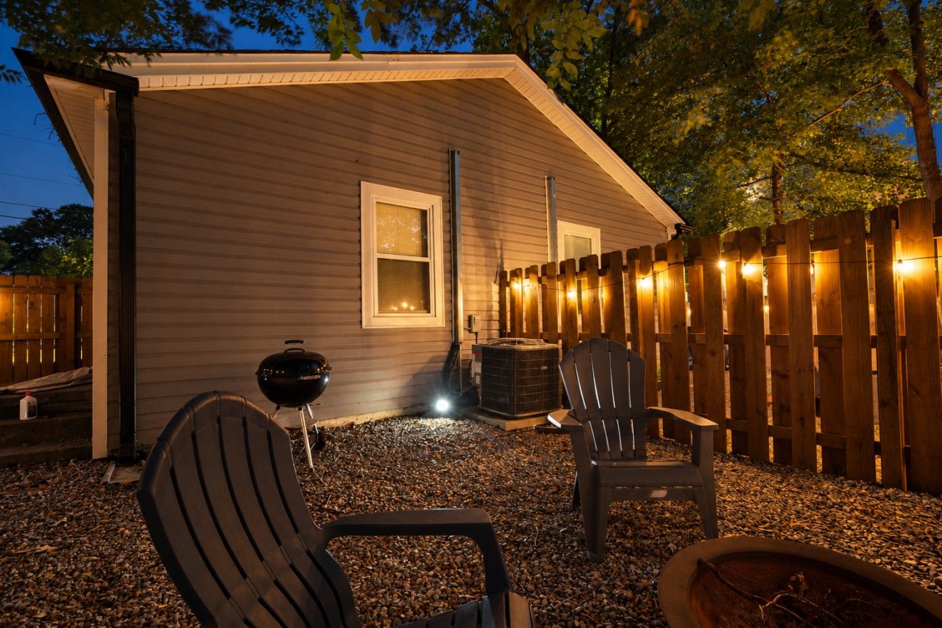 Un espacio al aire libre techado con una parrilla, una silla y un jacuzzi.