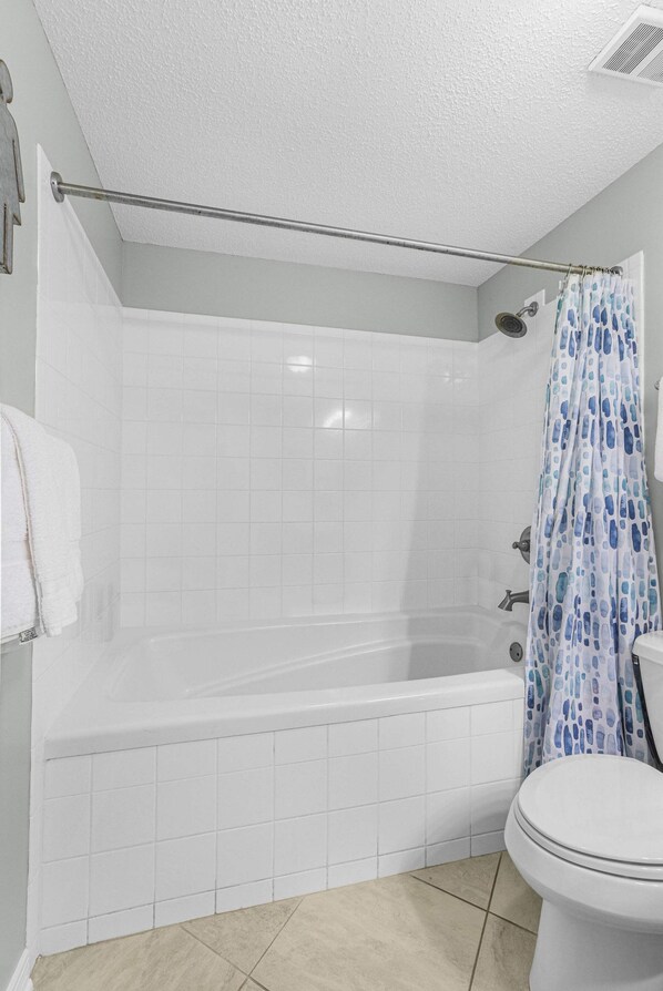 A bathroom with a bathtub, shower, and toilet. - Palms 915- Premier Beachfront Condo (Orange Beach)