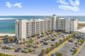 Un hotel de varios pisos con estacionamiento y vista al mar.